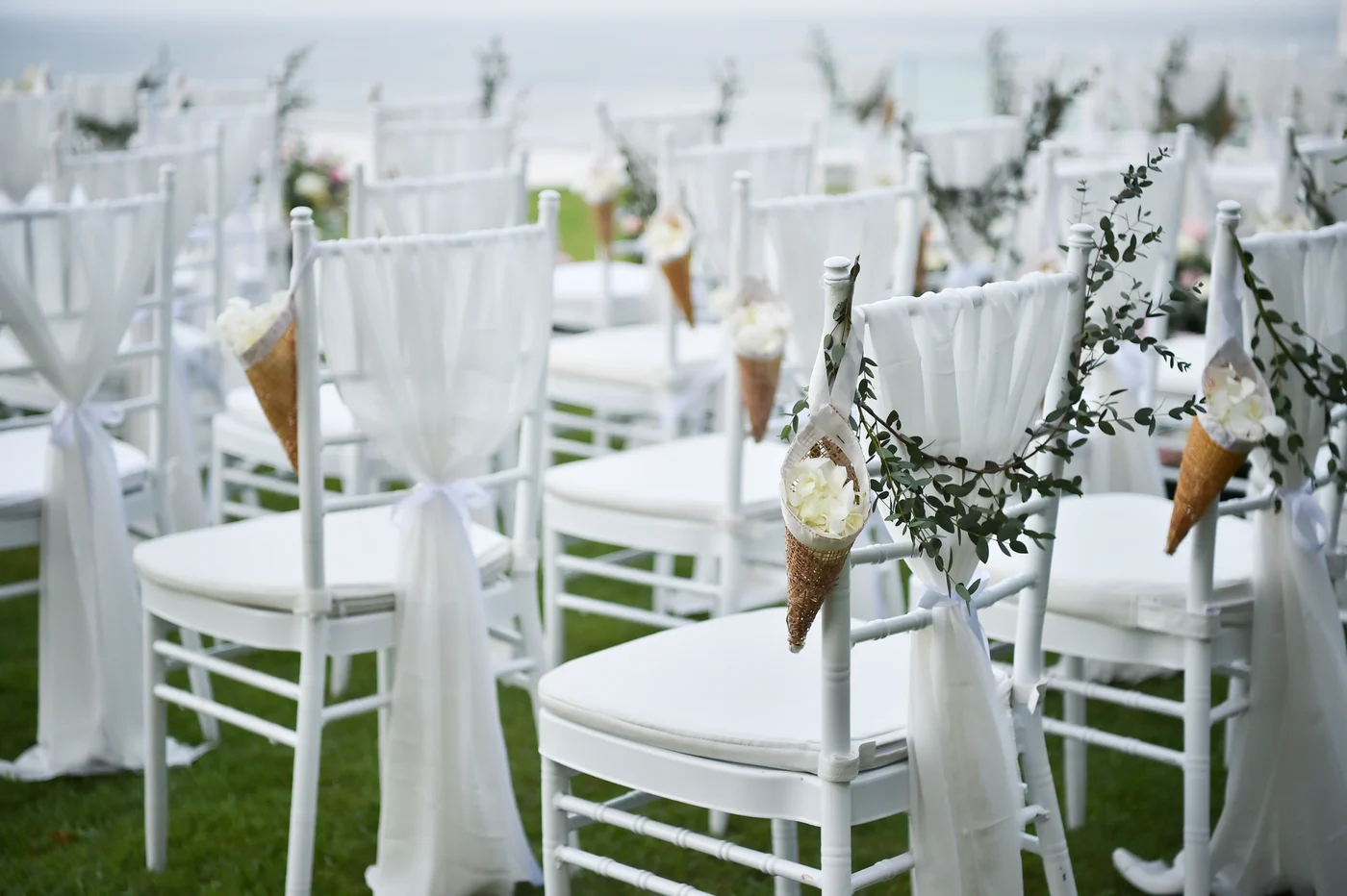 White ceremony chairs decorated with flowers