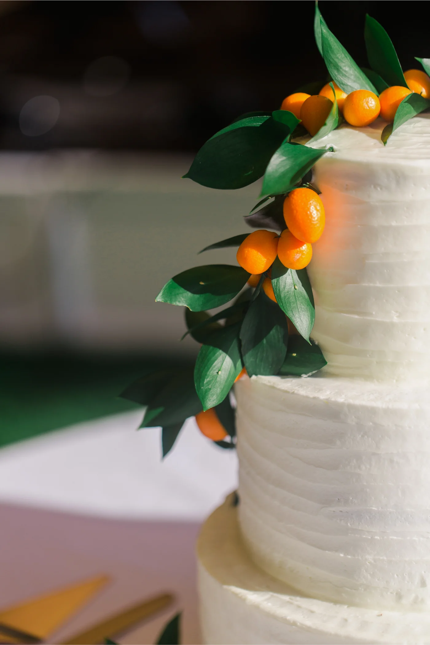 Wedding cake decorated with greenery and orange fruit